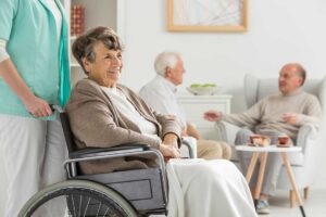 Two adult children reviewing assisted living documents with an older parent at a kitchen table.
